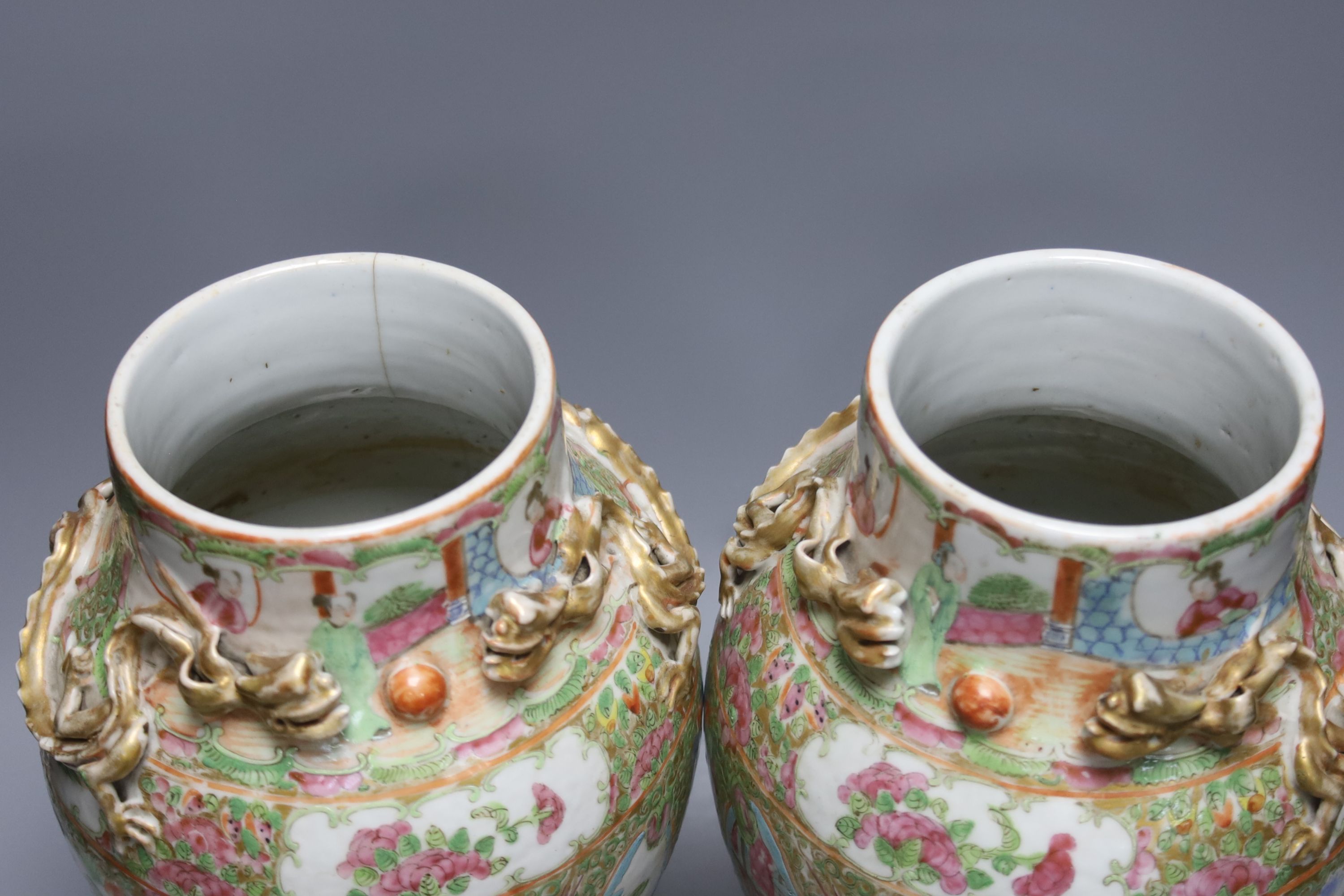 A pair of 19th century Chinese famille rose vases, height 30.5cm and a similar larger vase, 37.5cm (3)